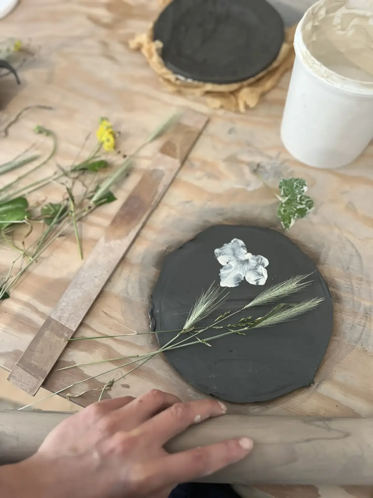 Modelage avec empreintes de fleurs et d'épis sur argile noire